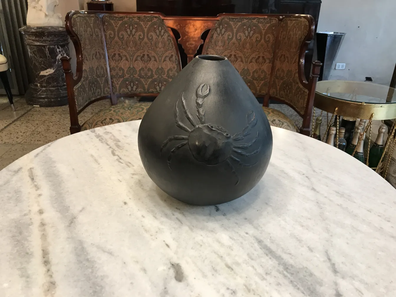 Vase en céramique noire avec motif de crabe, fond élégant
