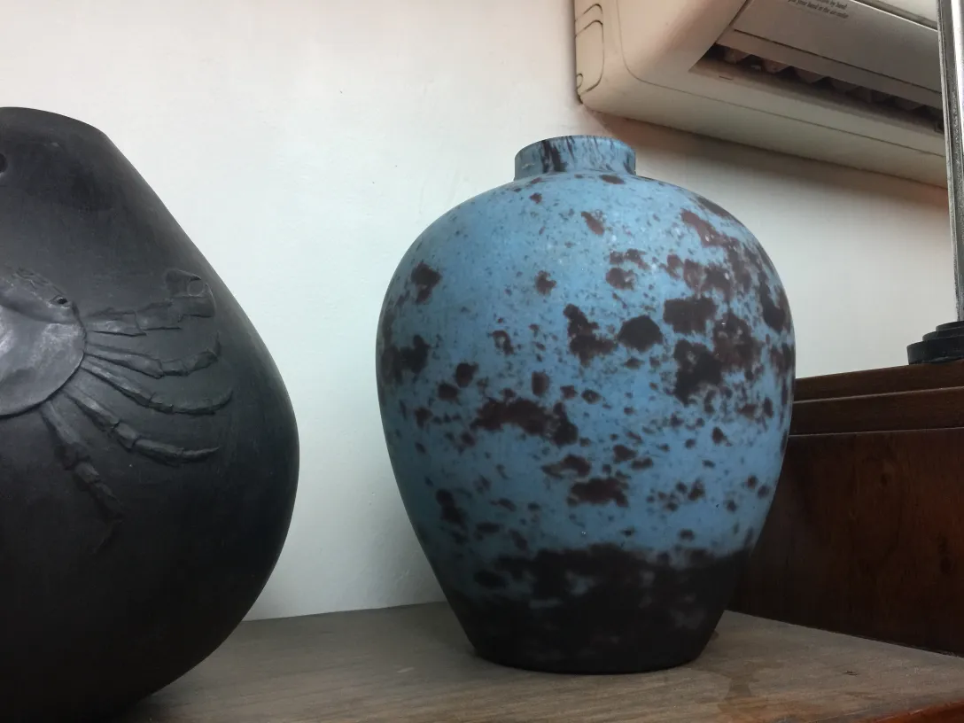 Cerâmica azul decorativa com manchas escuras em um ambiente antigo