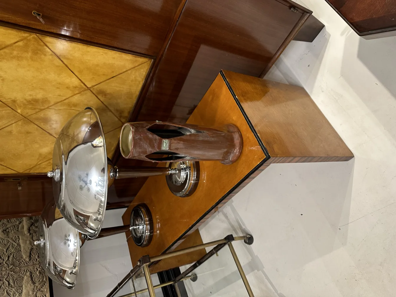 Cerámica antigua decorativa con detalles estilizados en un ambiente elegante, junto a objetos de metal.