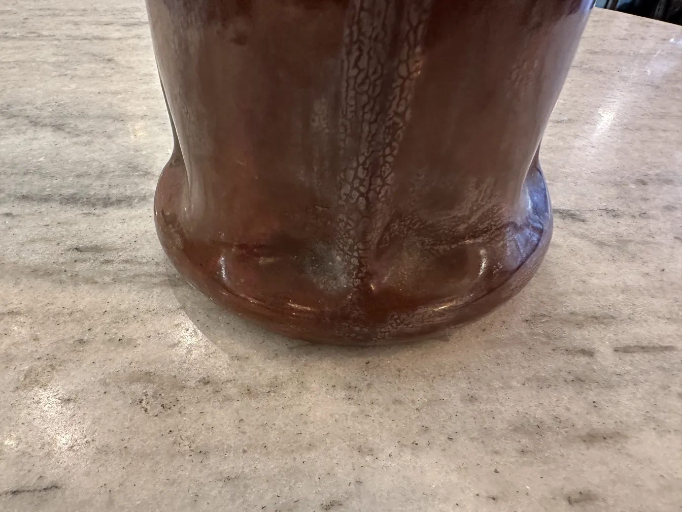 Cerámica antigua con diseño único sobre mesa de piedra.