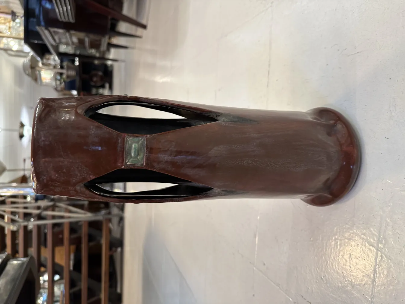 Vase en céramique ancienne avec design artisanal et détails uniques dans un cadre classique.