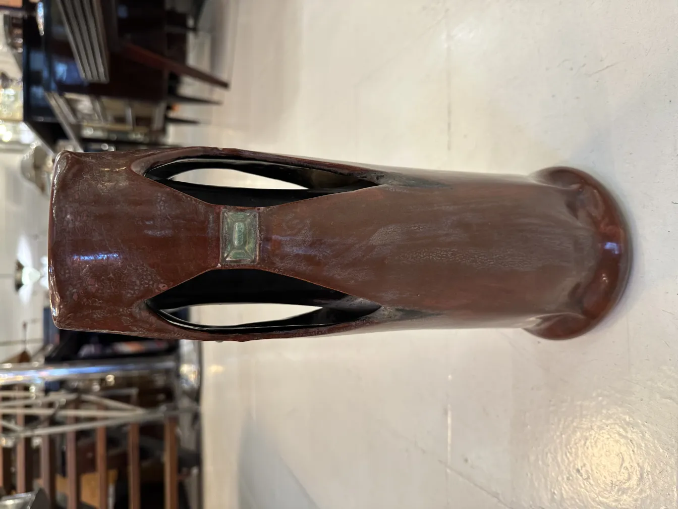 فازة سيراميك قديمة بنية اللون مع تصميم معاصر وتفاصيل فريدة، بيئة دقيقة.