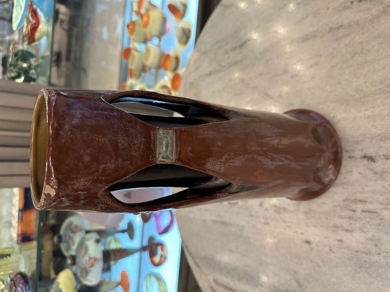 Antike braune Keramikvase mit ausgeschnittenem Design.