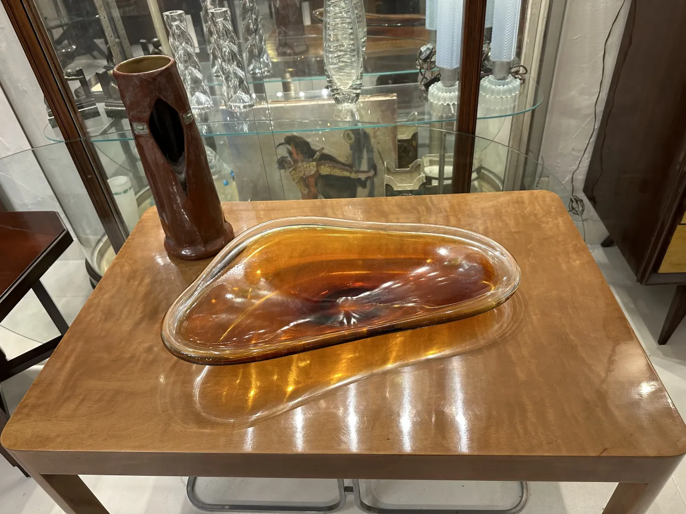 escultura de cerâmica antiga com formas fluidas e cor âmbar