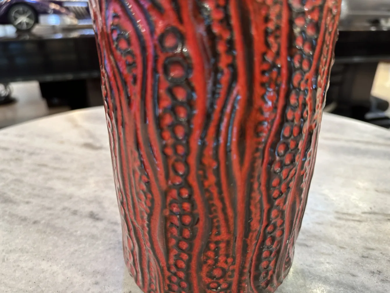 Céramique ancienne texturée rouge dans un cadre élégant.