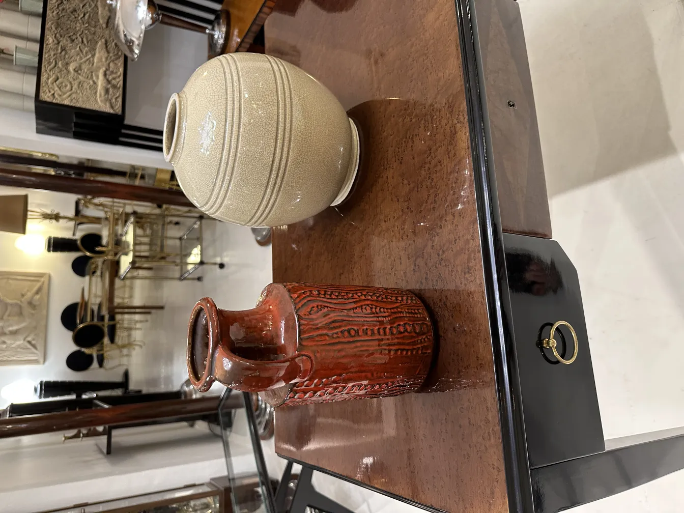 جرة السيراميك القديمة مع نمط بارز على طاولة خشبية لامعة.