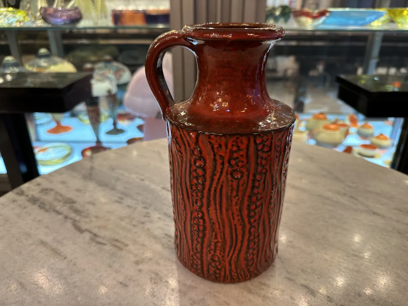 Antique red ceramic with textured design, decorative.