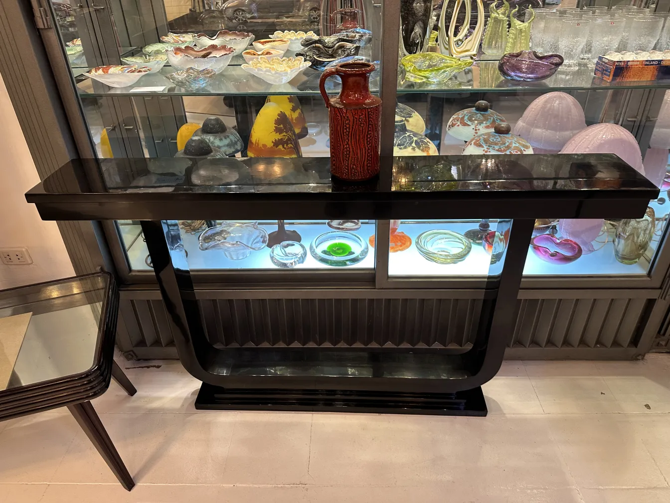 黒いテーブルの上にあるカラフルなデザインの古い陶器の花瓶、装飾的なアイテムに囲まれている。