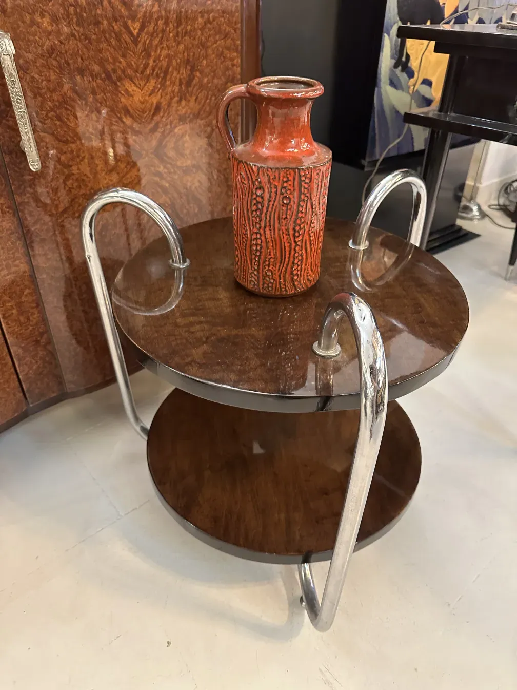 Vaso di ceramica antico con design testurizzato rosso, su un tavolo decorativo.