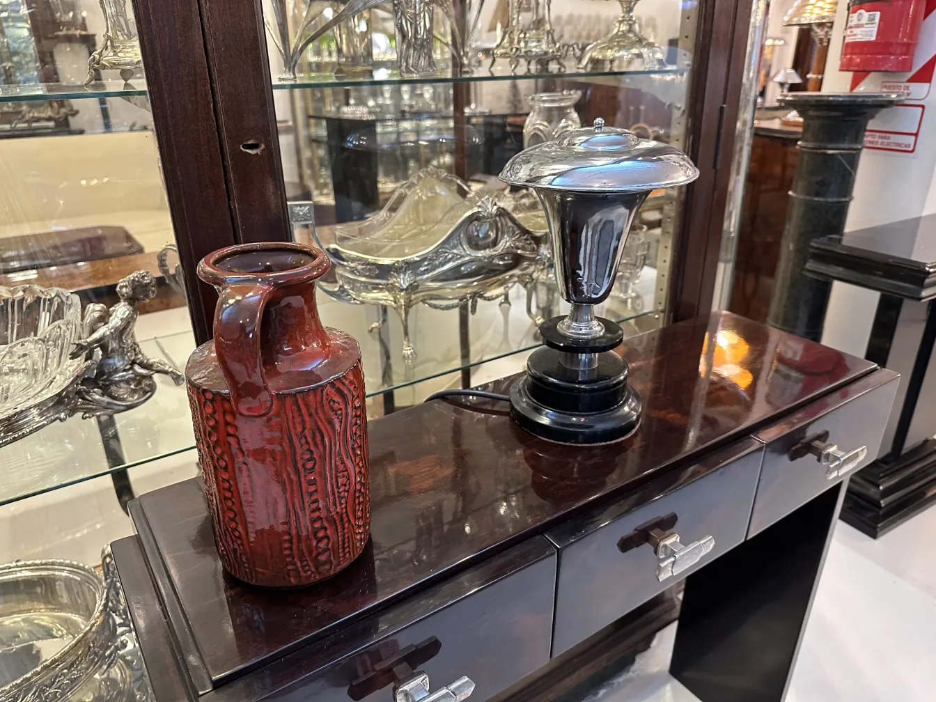 Vase ancien en céramique rouge avec texture, décoratif dans la vitrine.