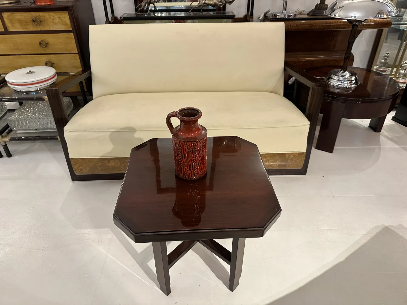 Vaso di ceramica rossa antiquariato su un tavolo in un soggiorno vintage.