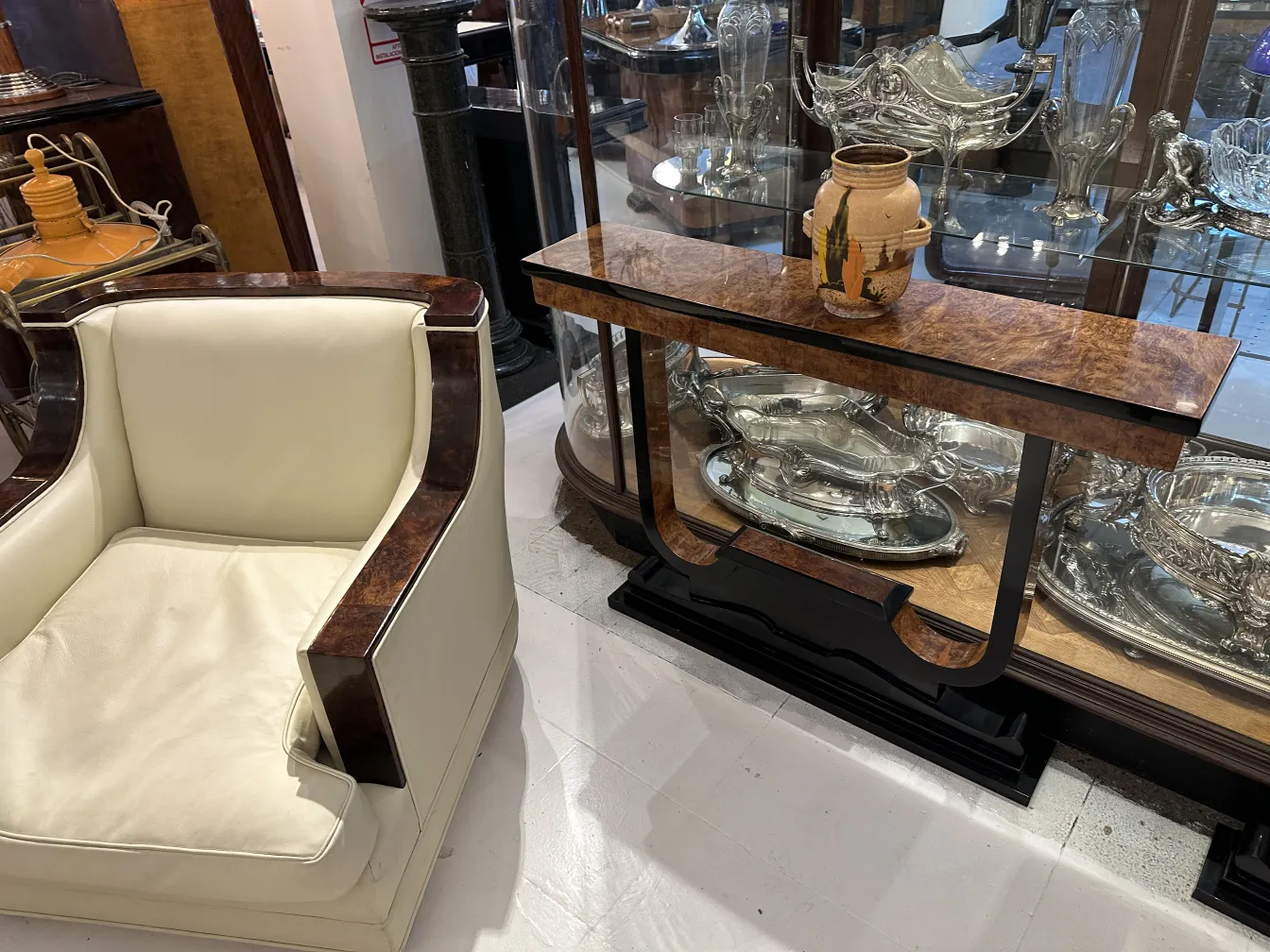 Antigua cerámica decorativa con diseño artesanal, exhibida en una vitrina y acompañada de muebles clásicos.