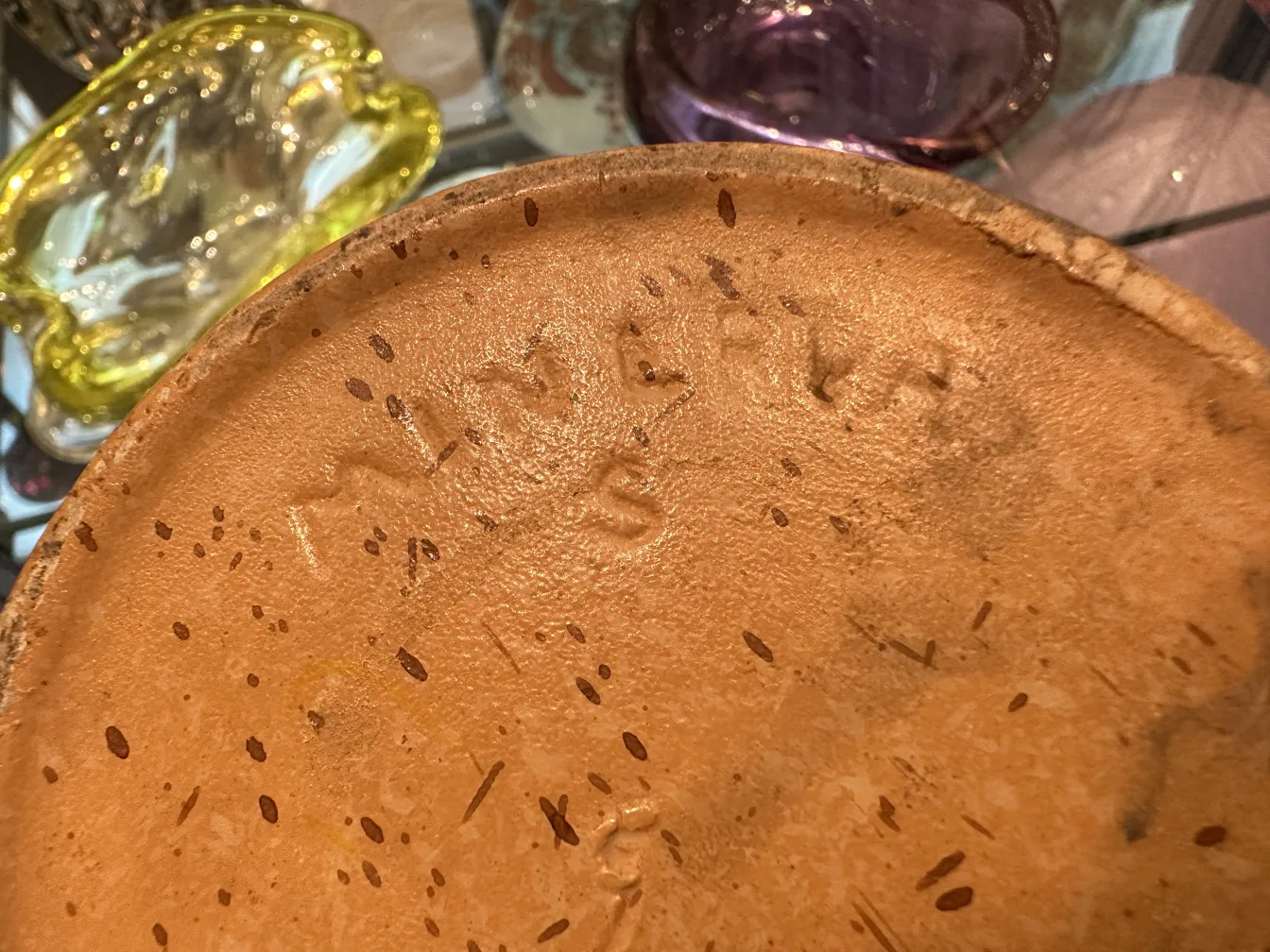 Bottom view of an antique ceramic with unique texture and markings.
