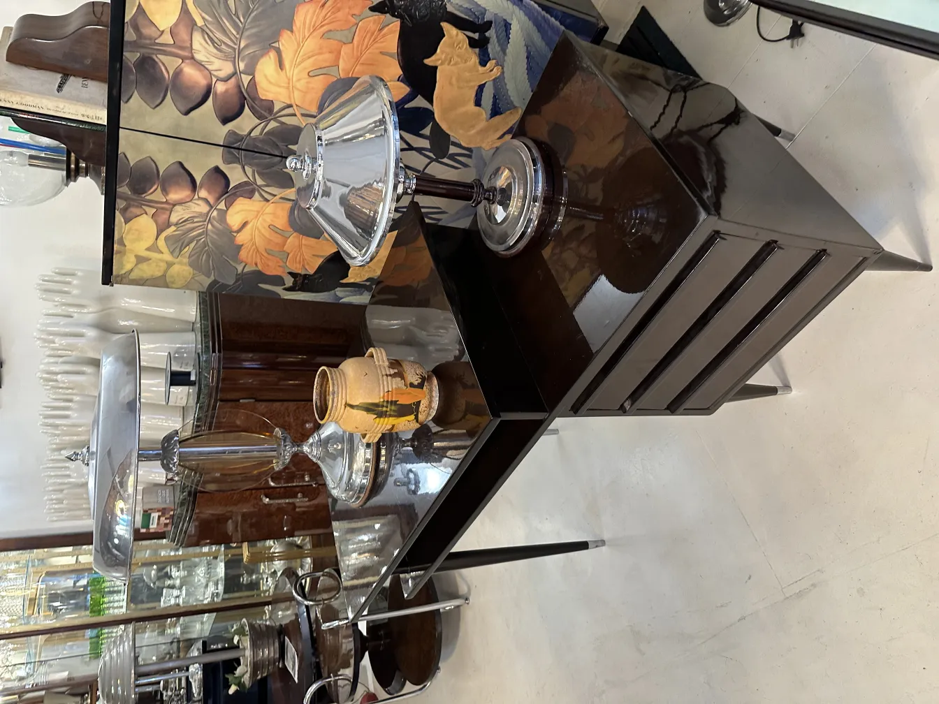 Vaso de cerâmica antiga com detalhes pintados em um ambiente elegante. Lanternas e fundo decorativo.