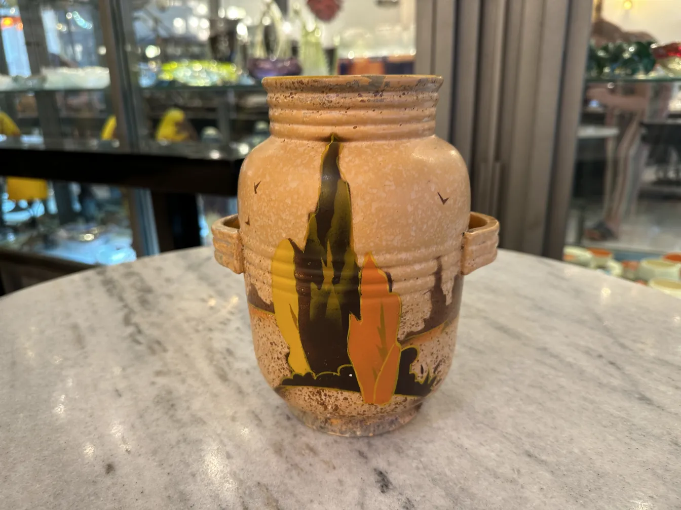 Jarrón de cerámica antigua con detalles artísticos en amarillo y negro, decorado con formas abstractas. Ambiente antiguo.