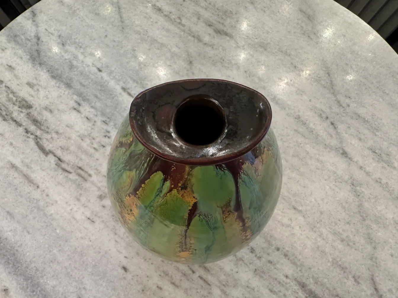 Colorful antique ceramic vase with intricate details. Marble background.