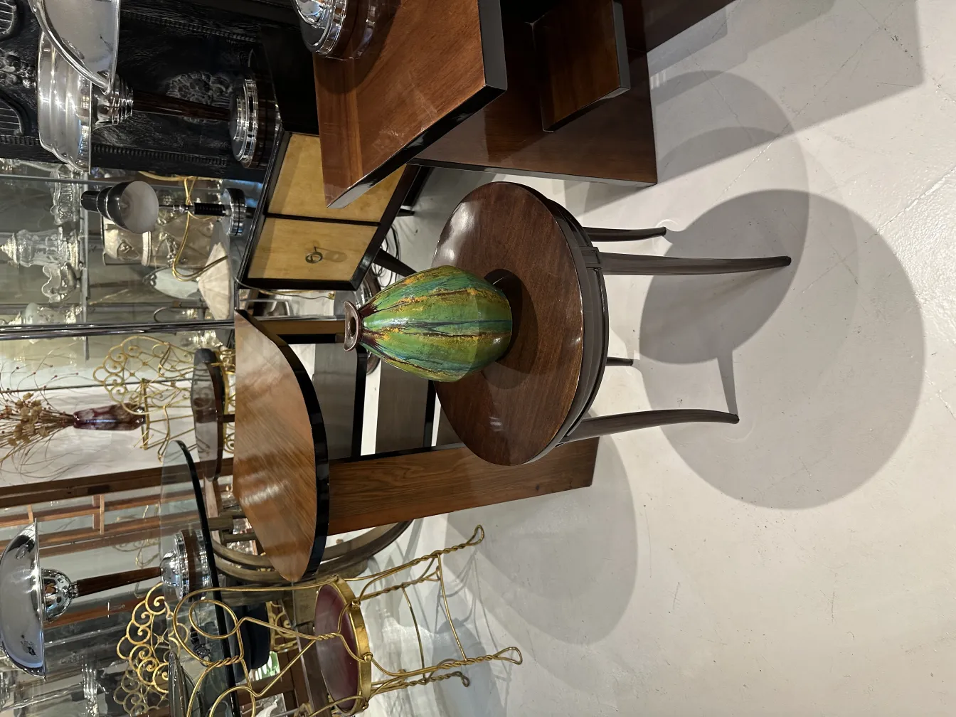 Jarrón antiguo de cerámica verde decorando una mesa de madera.