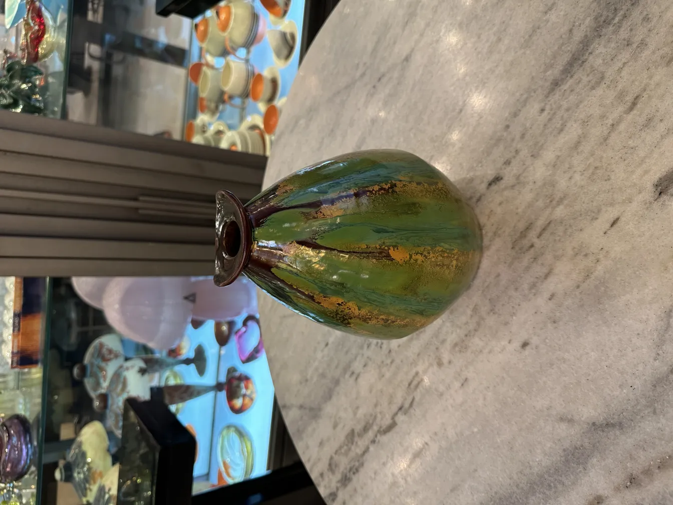 Vaso di ceramica antica verde con disegni, sfondo di antichità.