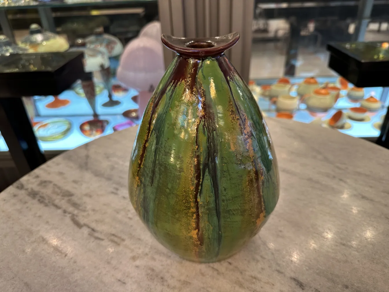 Vaso antiguo de cerámica en verde con detalles dorados.