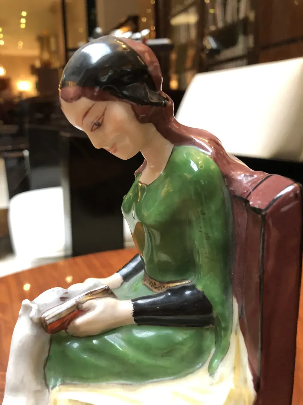 本を持った古い陶器の女性像。