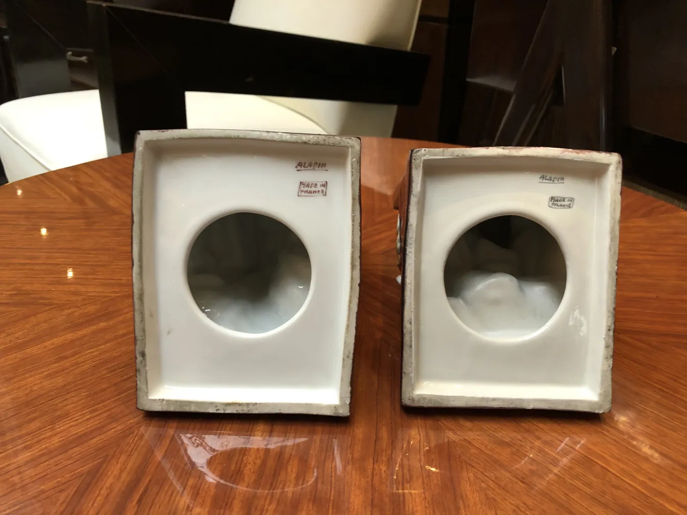 Dos piezas de cerámica antigua, con formas rectangulares y círculos, en un ambiente elegante.