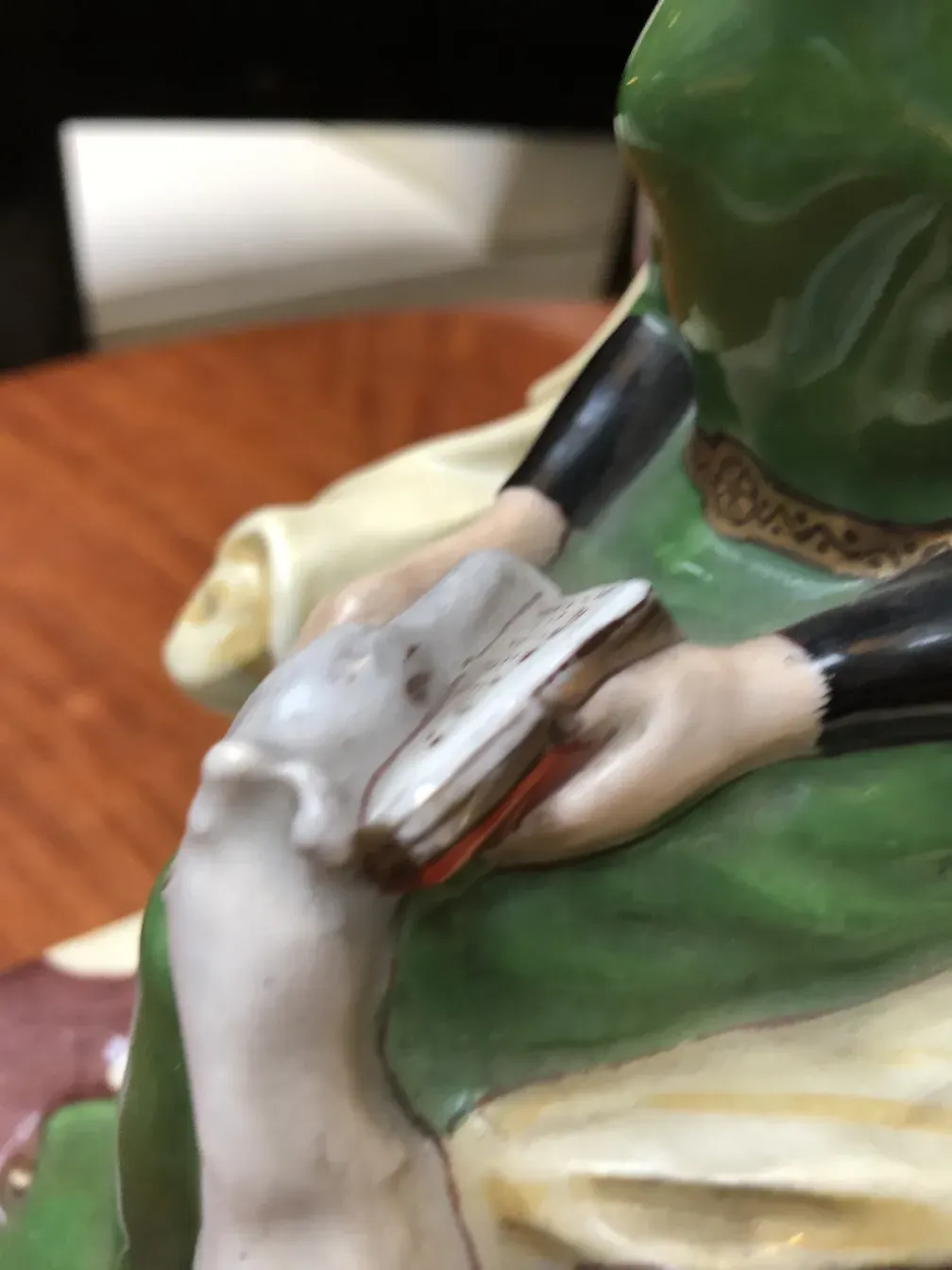 Figura artística de cerámica antigua en colores vibrantes, detalle en las manos.