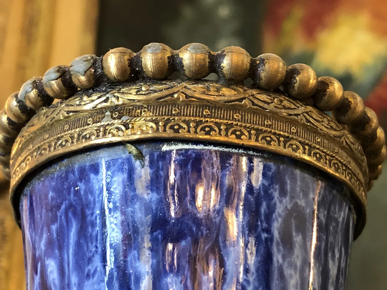 Tazza antica in ceramica blu e dorata, con dettagli ornamentali.