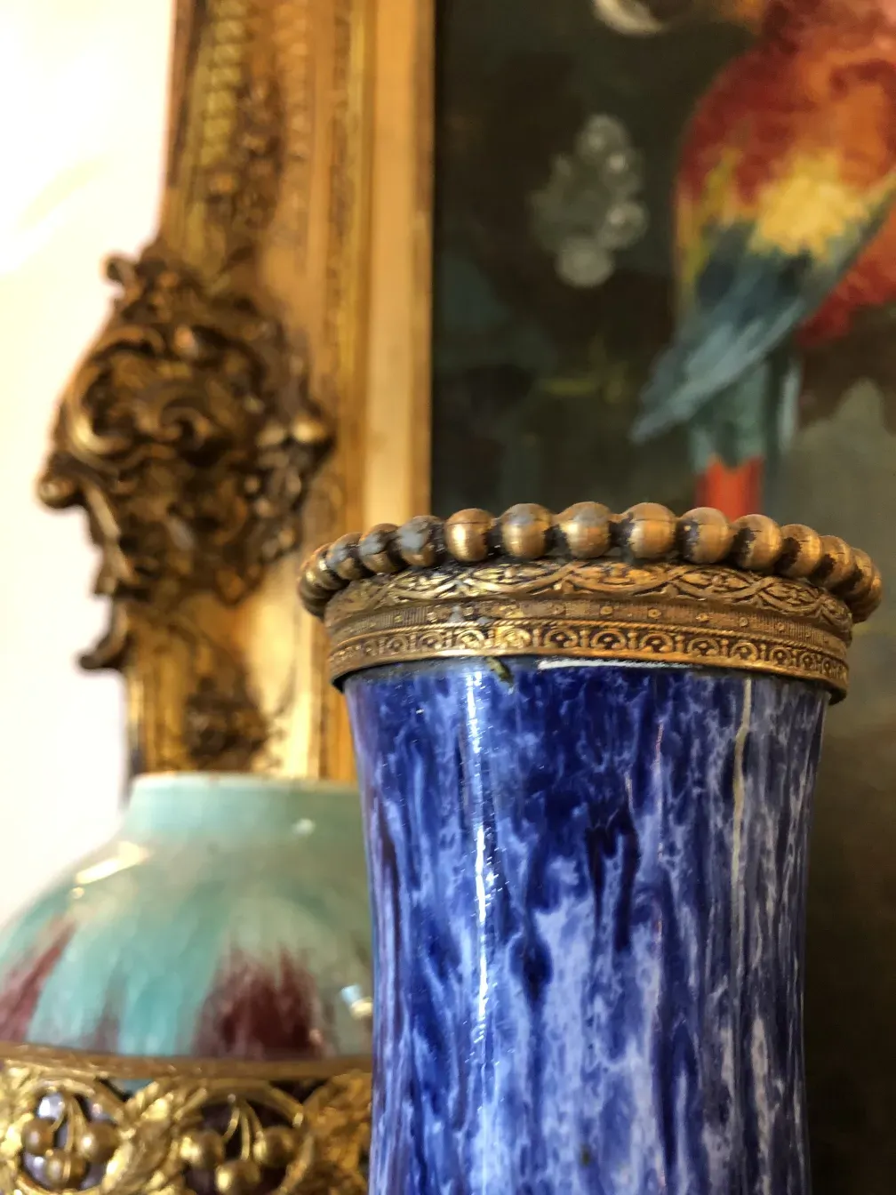 Ancien vase en céramique avec détails dorés, ambiance classique.