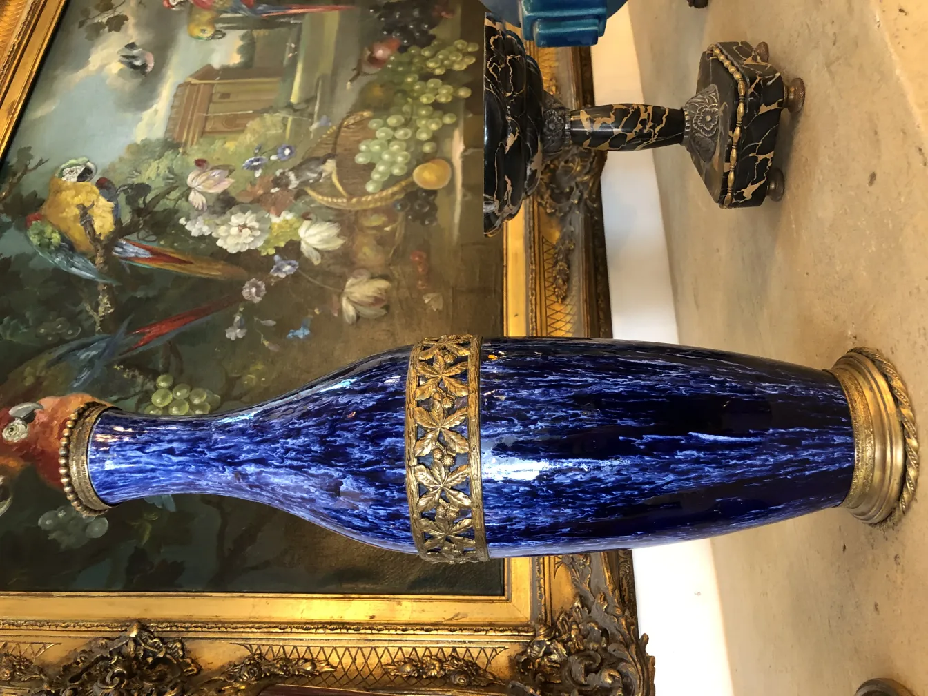 Vase de cerámica azul con detalles dorados, ambiente antiguo.