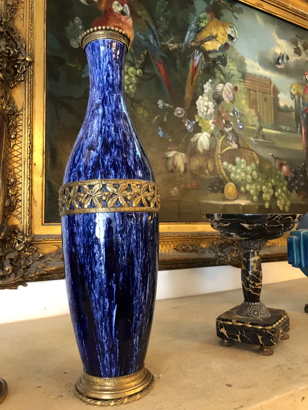 antike blaue Vase mit goldenen Details vor einem Kunsthintergrund