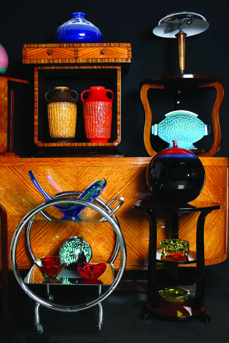 Collezione di antiquità in ceramica, con varie forme e colori in un ambiente decorativo.