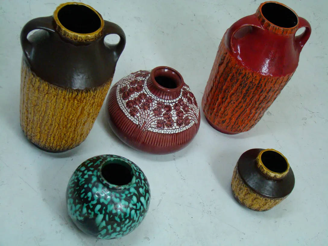 Vasos de cerâmica antiga de várias cores e formas em um fundo branco