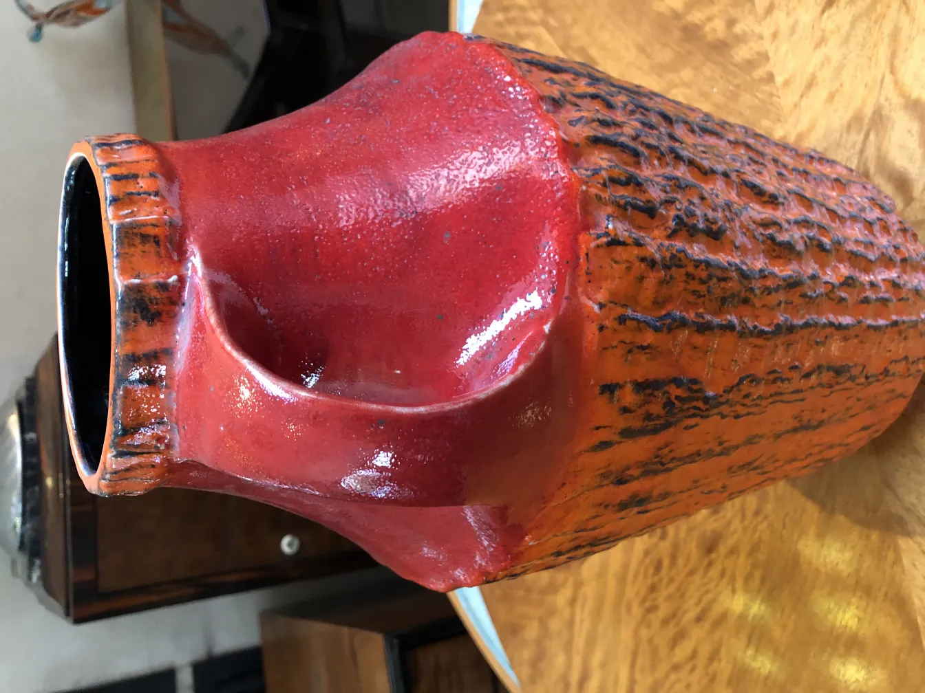 Helle rote antike Keramikvase mit strukturiertem Design.