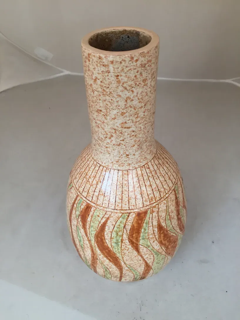 Altes Keramikobjekt mit bunten Designs am Körper.