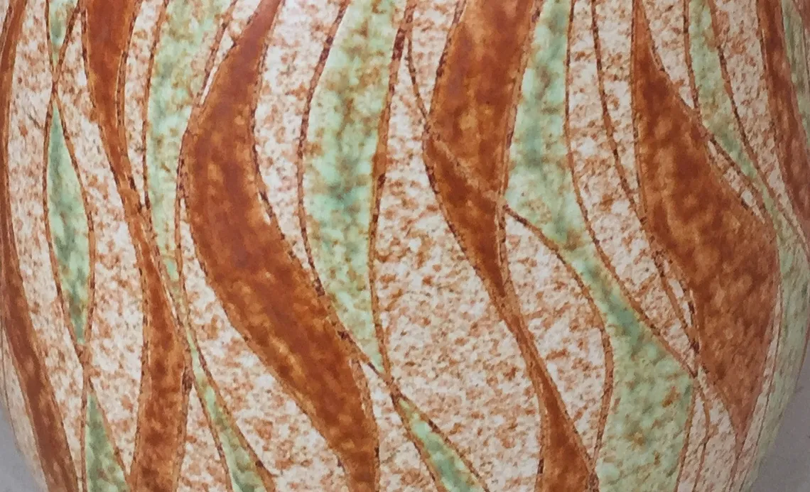 vase de cerâmica antiga com padrão abstrato em tons de terracota e verde