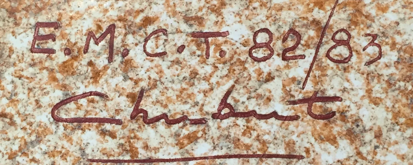 Cerâmica antiga com assinatura visível e textura distinta.