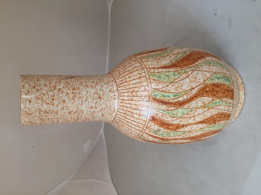 Vase en céramique ancien avec un design en brun et vert, élément décoratif.
