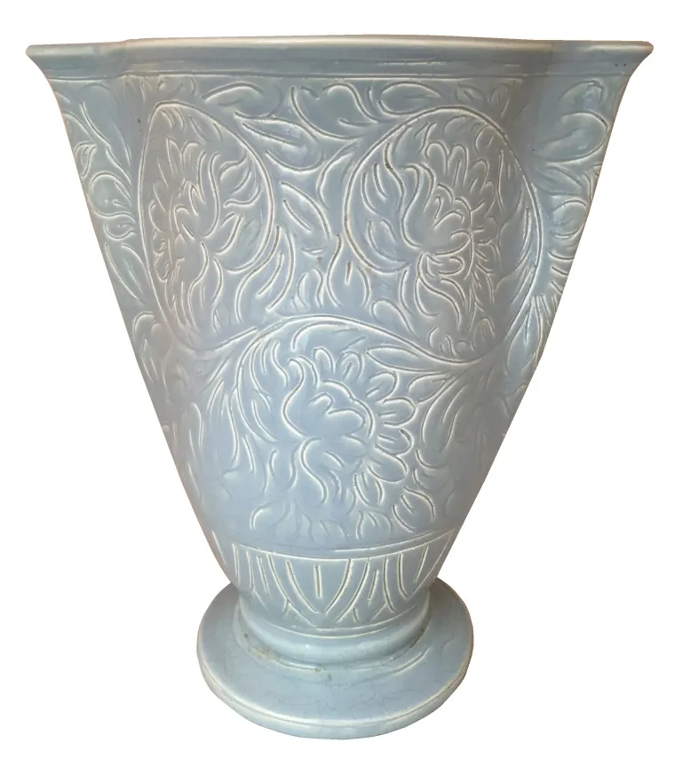 Vase en céramique ancienne avec décoration complexe dans un cadre rustique
