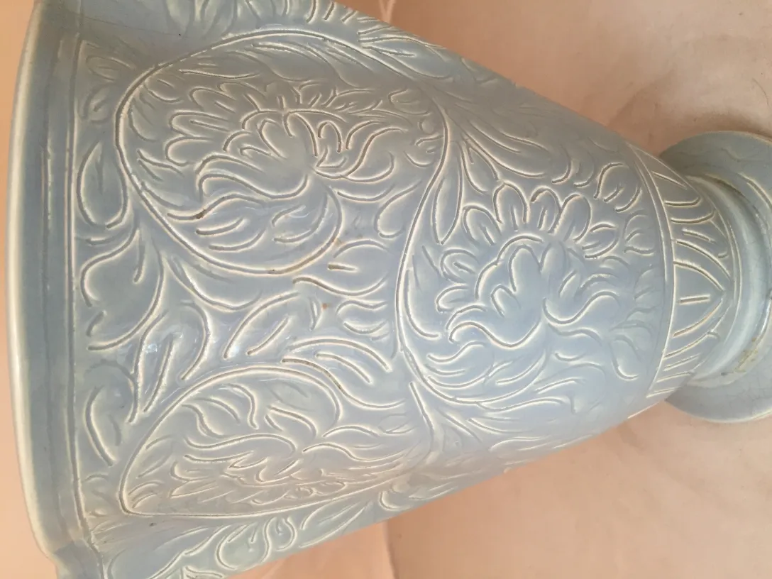 Cerámica antigua con detallado diseño floral en relieve, elegante y decorativa.