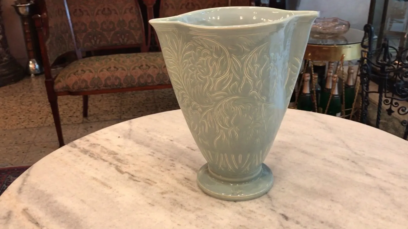 Ancient ceramic vase with intricate designs, set in a classic environment.