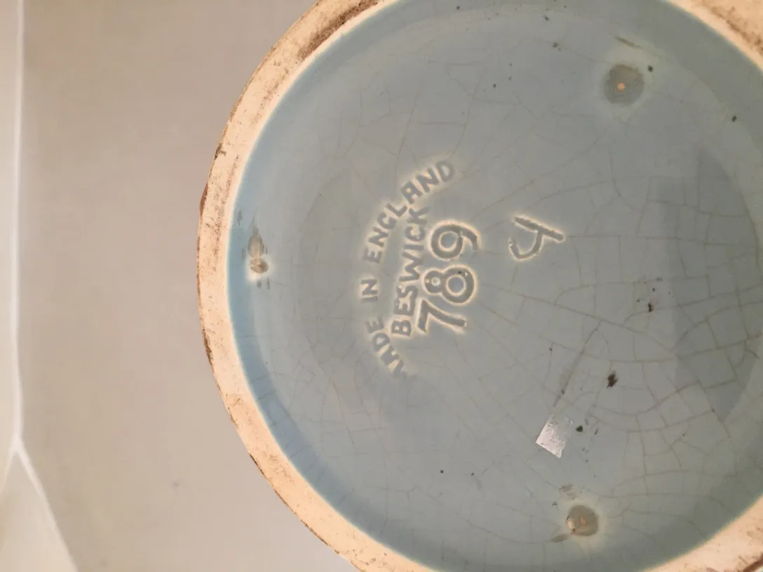 Base de cerâmica antiga azul com marcas.