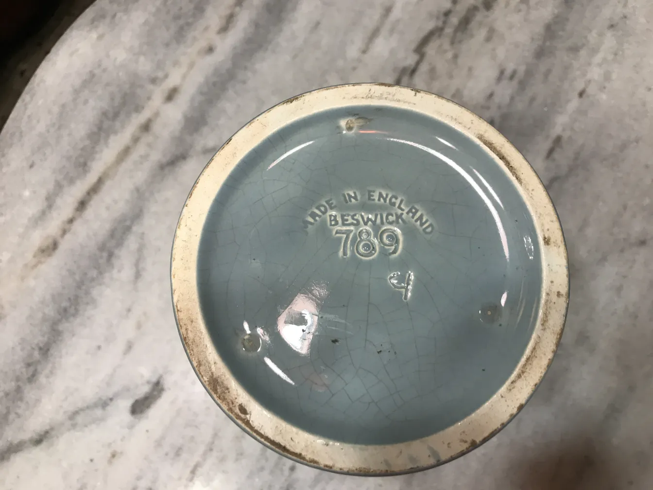 Antiga cerâmica Beswick com tom azul e marcas visíveis.