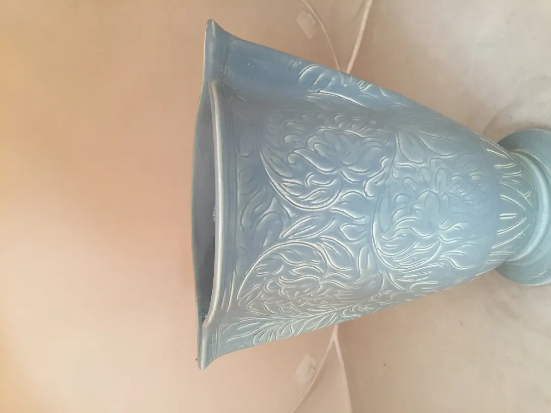 Vase en céramique ancienne décoré en bleu clair avec des motifs floraux