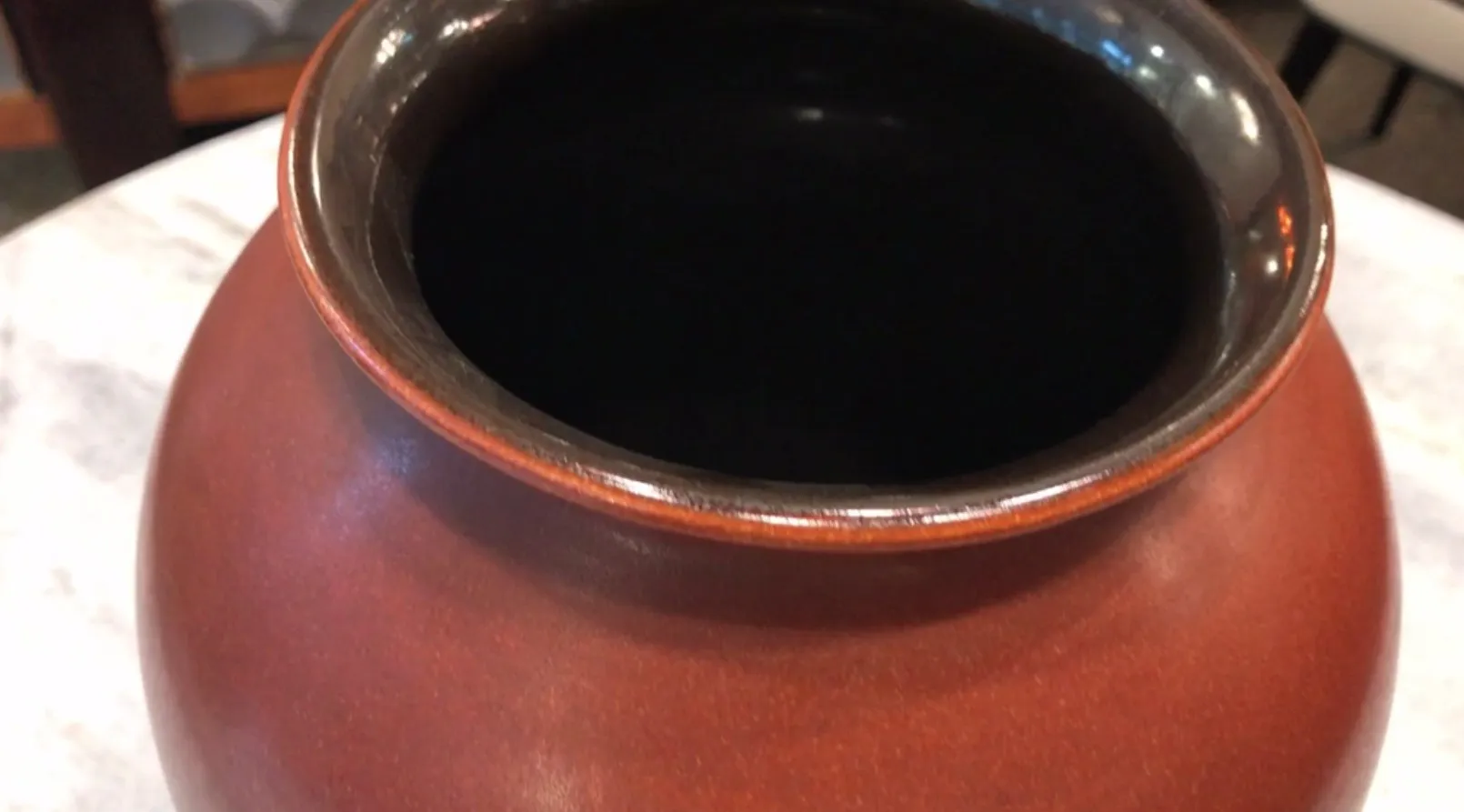 暗い内部を持つ古代の陶器の壺。