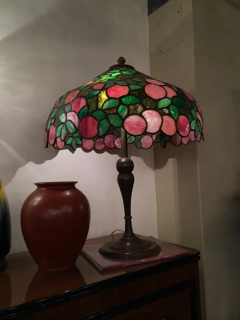 Lámpara de cerámica antigua con diseño floral colorido en un ambiente acogedor