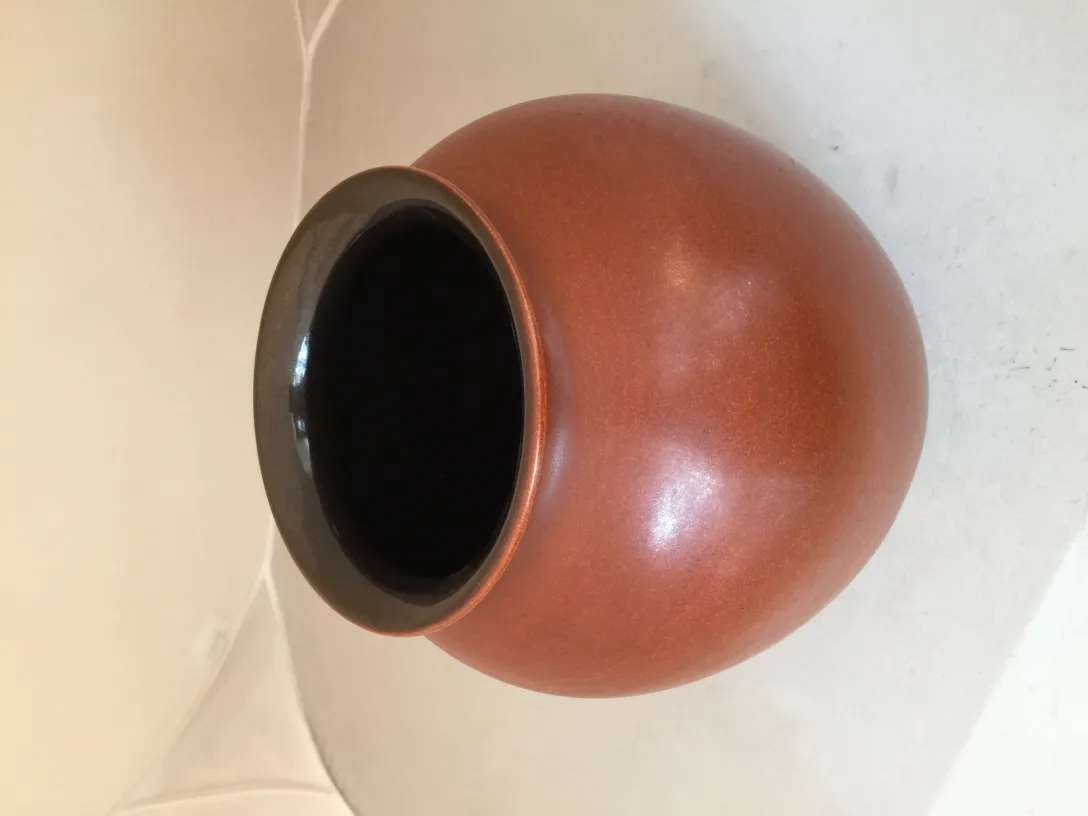 古い黒い縁の陶器の花瓶、明るい背景