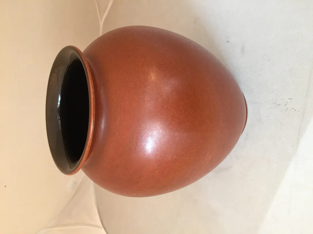 Vaso antico in ceramica marrone con bordo nero.