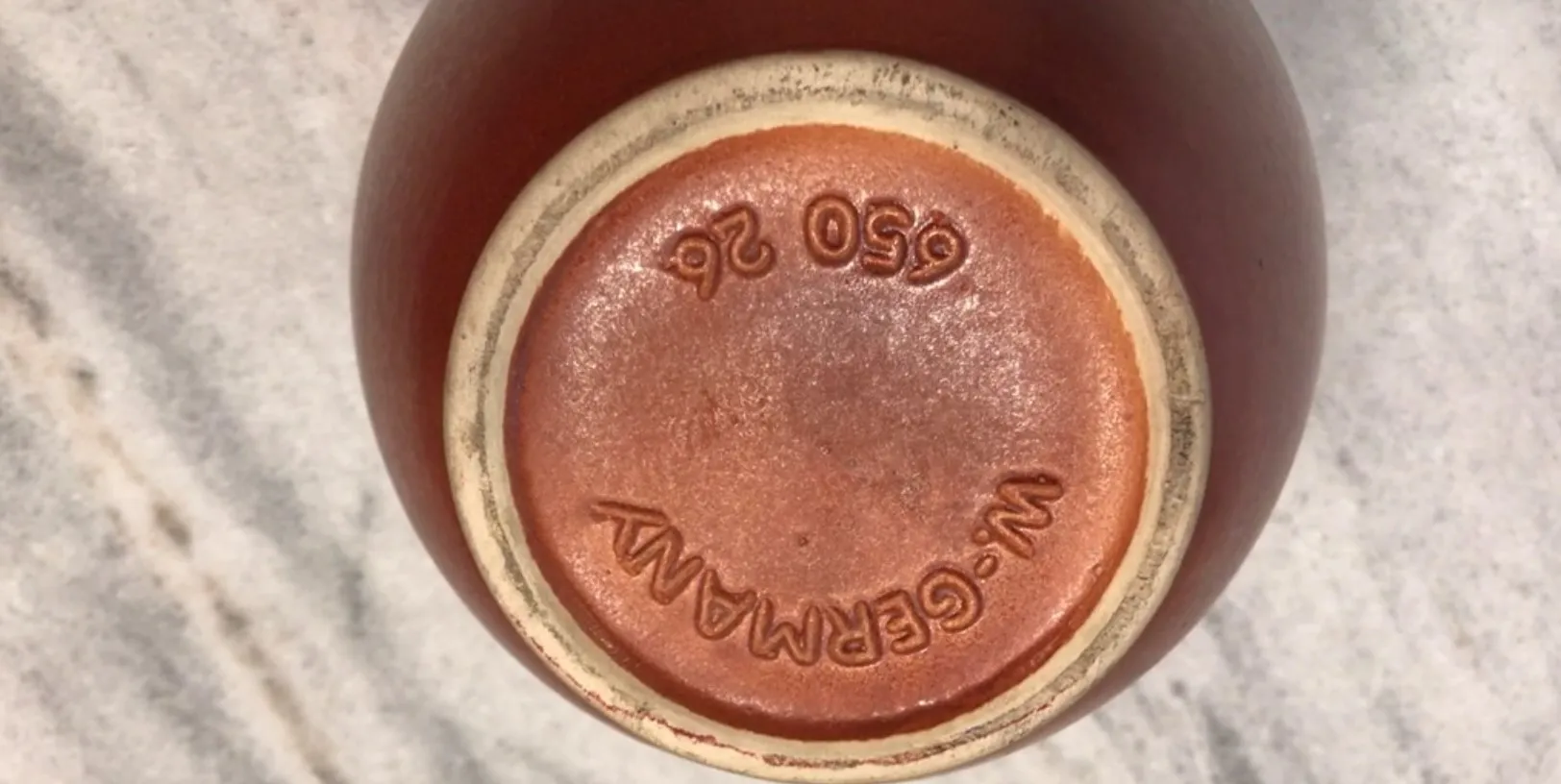 Céramique artisanale ancienne avec un design rustique unique, vue par le bas.