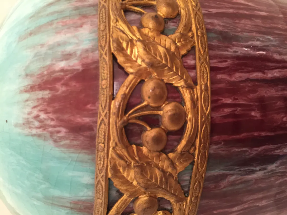 Ceramica antica con complessa ornamentazione dorata su sfondo multicolore.