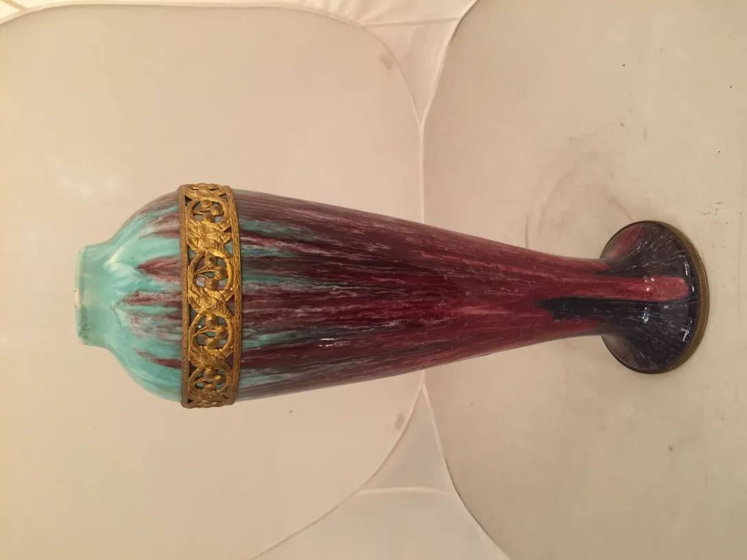 Antique ceramic vase featuring colorful patterns and a golden rim.